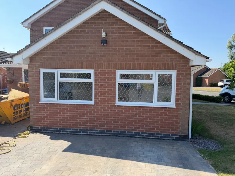 Armison’s Bedworth garage conversion exterior with brick infill and two white windows