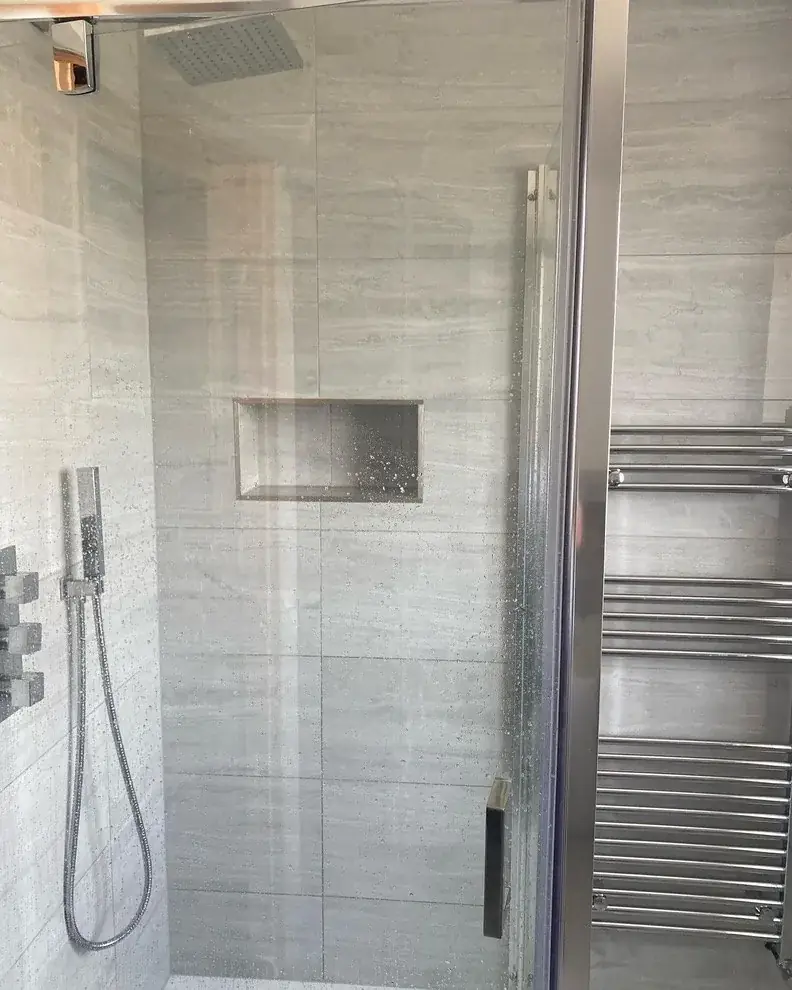 Armison shower-room detail with a rainfall shower, recessed shelf and chrome towel radiator
